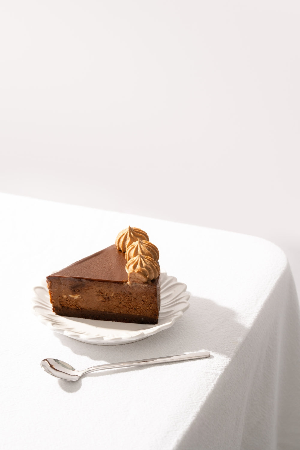 Un trozo de cheesecake de chocolate sobre un plato. 