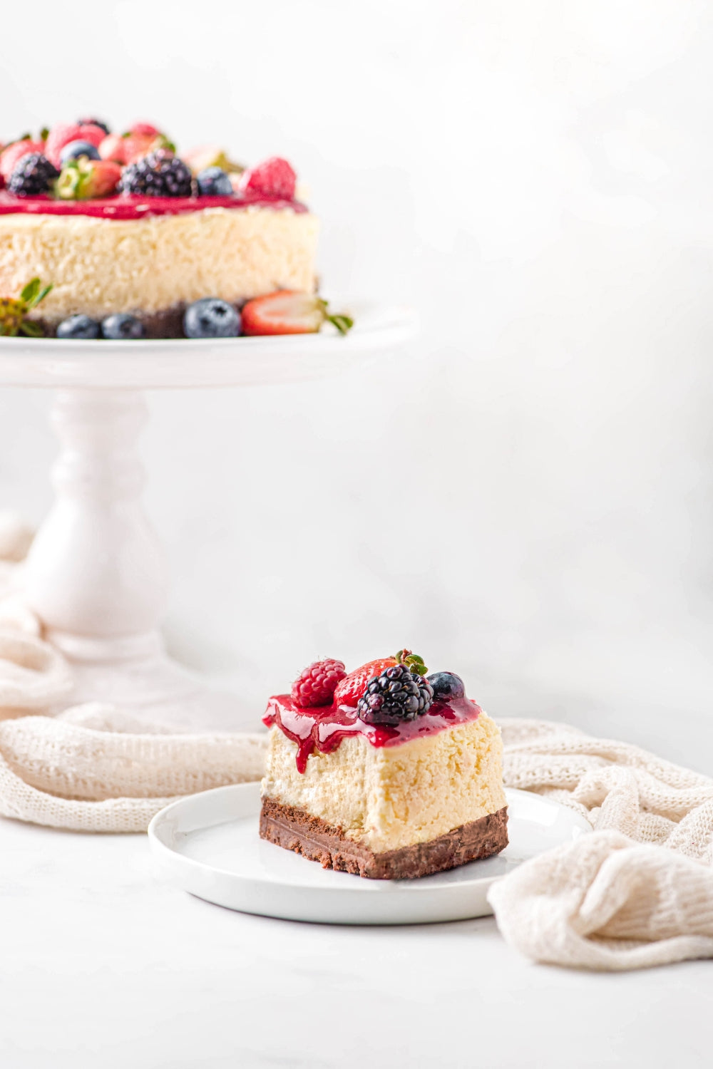 Un trozo de cheesecake de frutos rojos sobre un plato. 