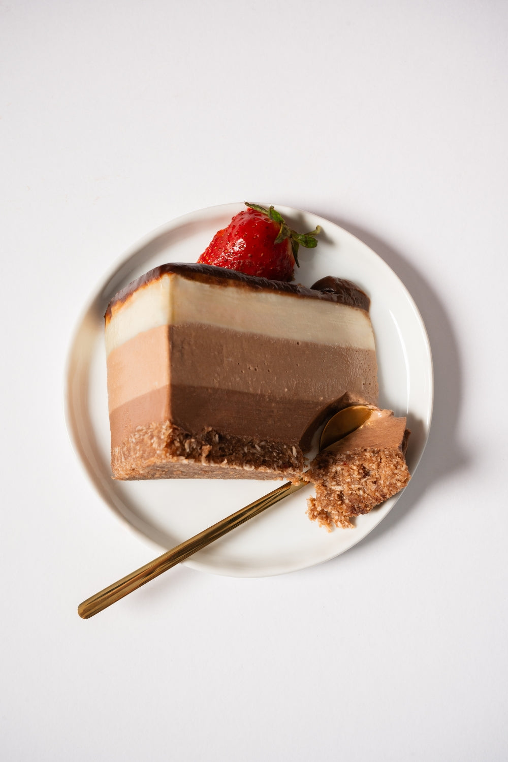 Un trozo de cheesecake de triple chocolate sobre un plato.