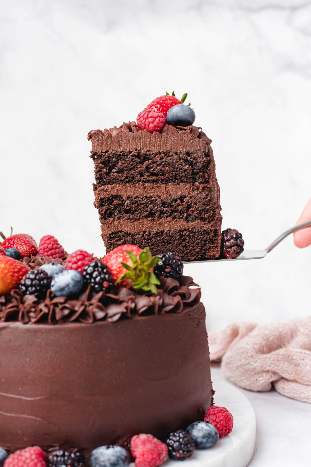 Un trozo de torta de chocolate siendo cortado.